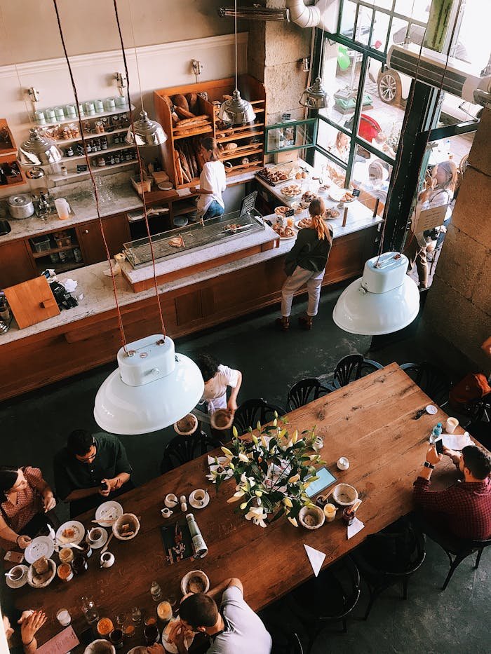 A vibrant aerial view of a busy cafe in Kraków, showcasing patrons enjoying baked goods and coffee.